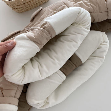Cream Cloud: Soft off-white quilted jacket for a fresh, stylish look. Features a durable construction and easy-to-use snaps for quick dressing.